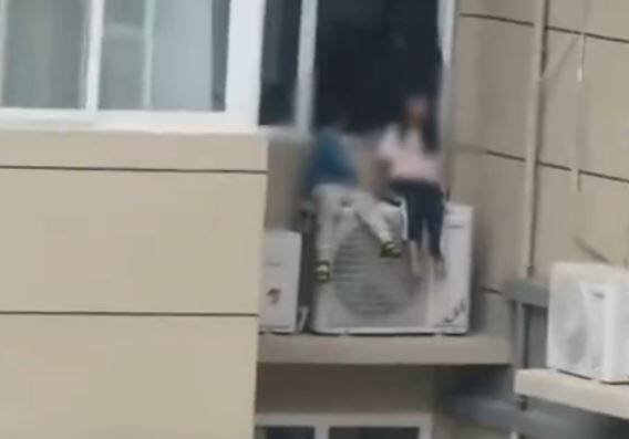 中国河南省洛阳市1对父母疑因争执,将2名子女丢在23楼高的冷气室外机上。(撷取自微博) 中国河南省洛阳市1对父母疑因争执,将2名子女丢在23楼高的冷气室外机上。(撷取自微博)