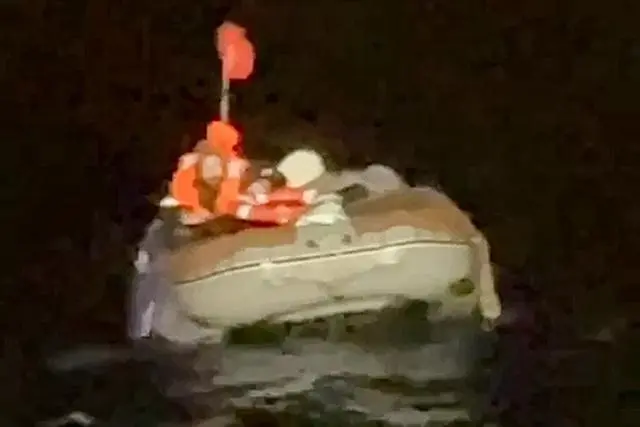 (皮丘金在获救前几分钟在一艘灰色充气船上呼救。)