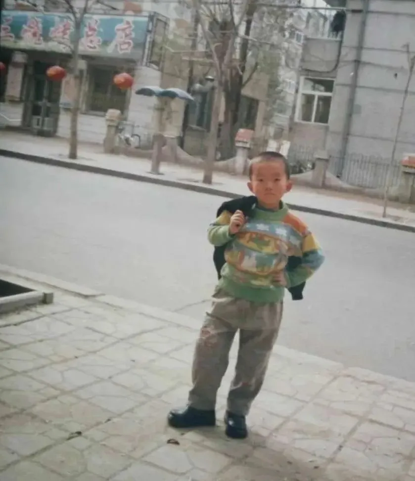◎ 童年的小奇,摄于妈妈理发店门口