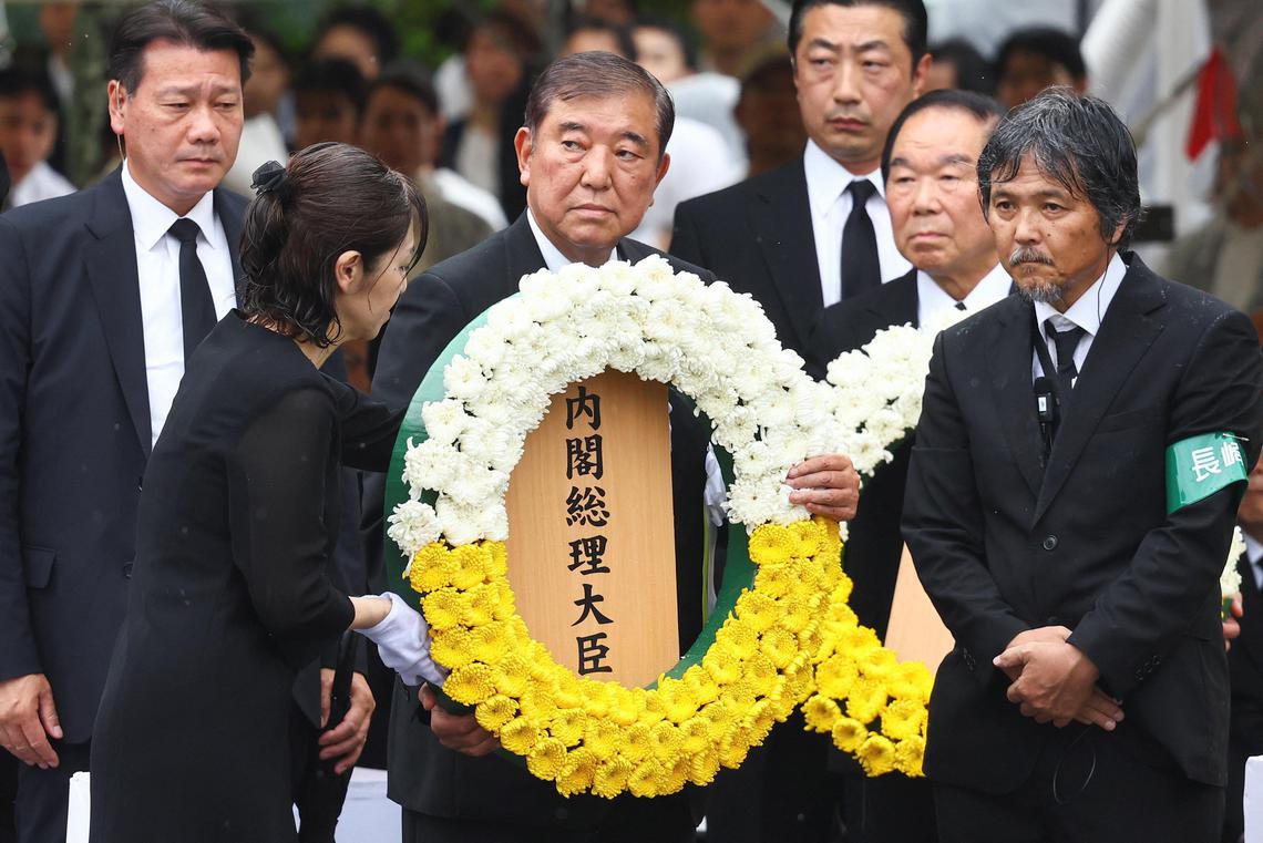 8月9日，日本首相石破茂（中）在长崎和平公园举行的原子弹爆炸80周年和平祈愿仪式上，向1945年原子弹爆炸的受害者敬献花圈。 （路透社）