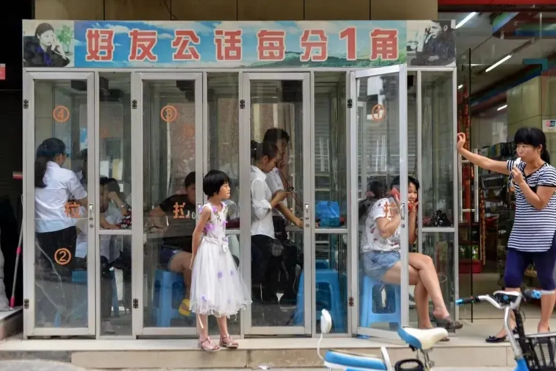 2016年6月1日,广东东莞,公共电话亭内的打工人。当时工业区的花费每分钟一角钱