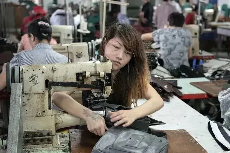 2012年6月18日,广东省东莞市,阿婷在用电车缝手袋