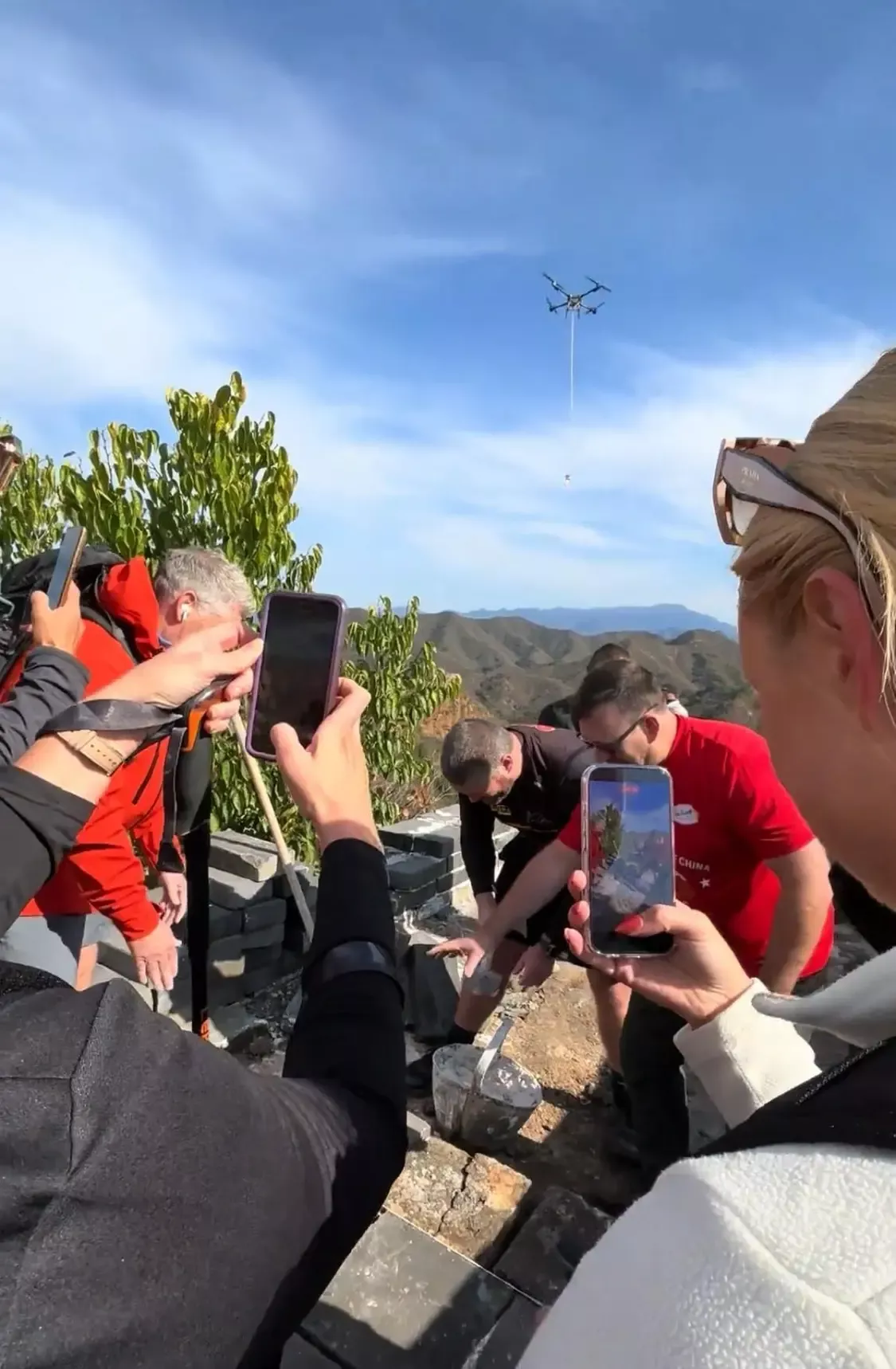 老外游长城遇无人机运材料纷纷惊叹 还现学铺青砖
