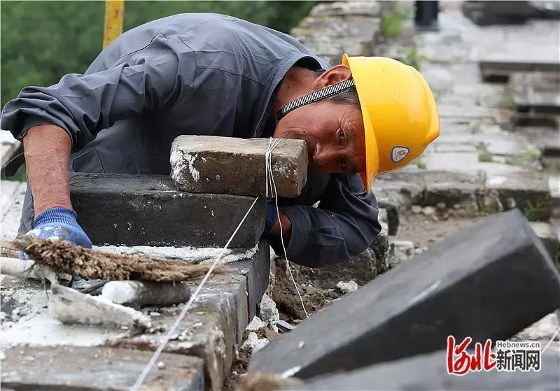 老外游长城遇无人机吊运材料纷纷惊叹,还现学铺青砖体验“修长城”