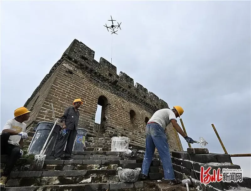 老外游长城遇无人机吊运材料纷纷惊叹,还现学铺青砖体验“修长城”