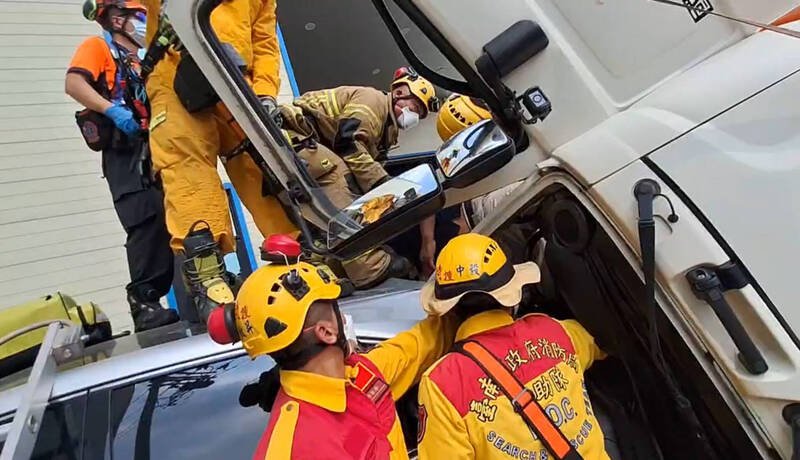 台南市永康区洲工街7日上午发生水泥预拌车翻覆，消防人员以破坏器材协助驾驶脱困送医。（读者提供）