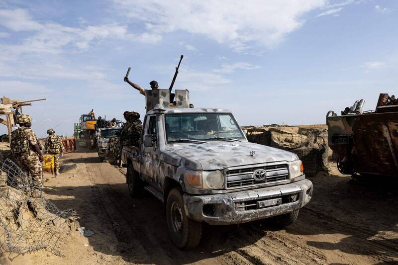 奈及利亚「伊斯兰国西非省」和博科圣地互为竞争对手，2个组织的武装份子今年已占领了10几个军事基地。图为7月在博尔诺州蒙古诺镇，一支由多国联合特遣部队护送的挖土机正在挖掘战壕，并通过检查站。（法新社档案照）