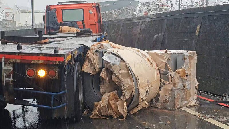 钢卷掉落路面，砸毁围墙。（记者吴升儒翻摄）