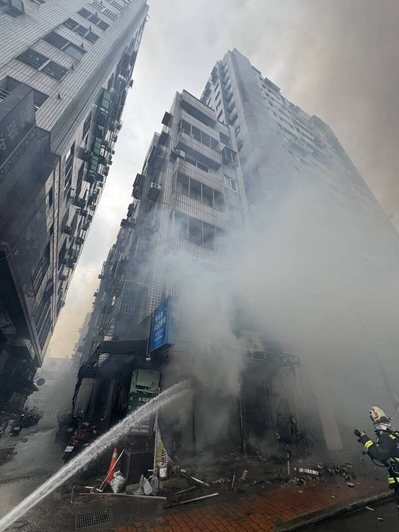 火场浓烟狂窜，消防人员拉水线灌救。（民众提供）