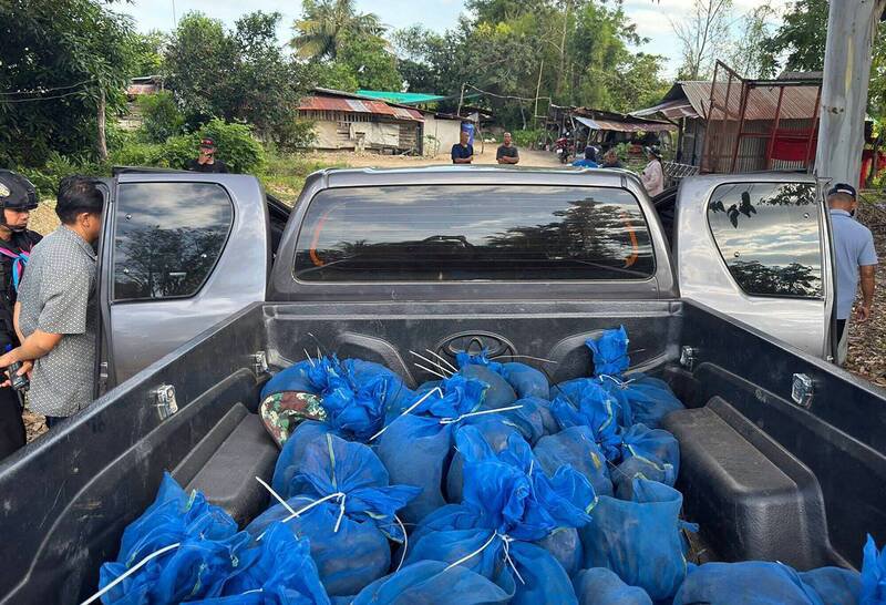 2名野生动物走私犯在泰柬边境被逮，大量被塞在蓝色网袋内的猕猴得以获救。（法新社）