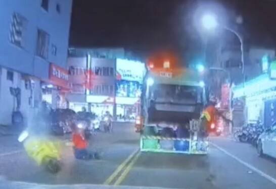 红色上衣的邱姓妇人倒完垃圾后，要穿越马路回去，与机车相撞倒地，伤势严重。（取自《仁德生活圈》）