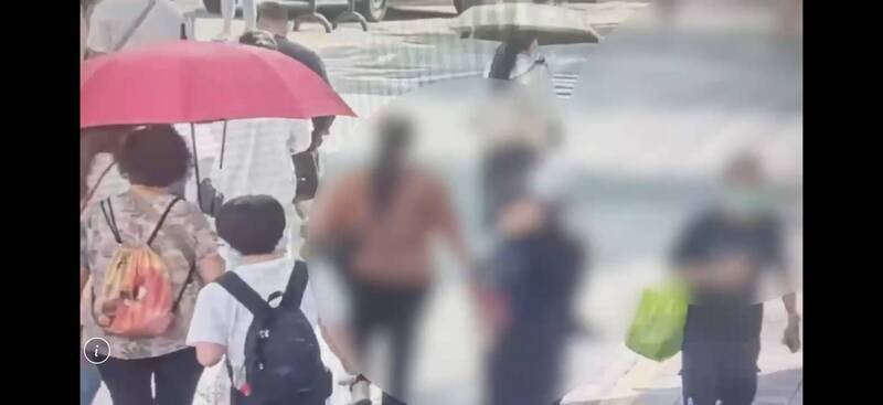 傅男（带绿色袋子男子）犯案后离去的身影。（记者邱俊福翻摄）