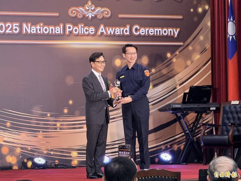 警政署今天举办年度「114年国家警光奖颁奖典礼」，中华民国警察之友总会理事长蔡明忠颁奖给团体组获奖的屏东县警局，由局长甘炎民领奖。（记者邱俊福摄）