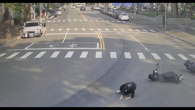 骑士行经弯路时，因道路油渍打滑自摔。（民众提供）