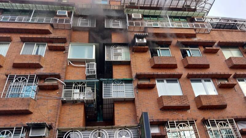 邻近万芳医院捷运出口对面的一栋大楼4楼发生火灾。（记者郑景议翻摄）