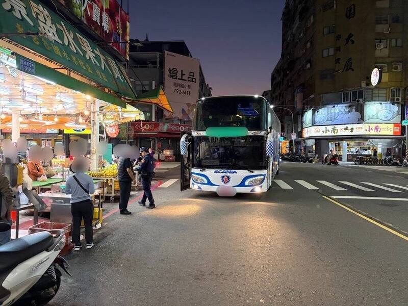 游览车于林森二路与兴中一路口左转时，右车头撞凹水果店的遮雨棚，等候员警到场时，乘客下车买水果，让不少路人误以为游览车大方违停路口下客。（民众提供）