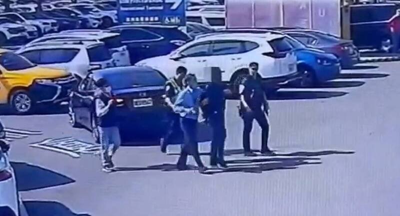 外籍嫌犯（右2）从国际线入境航厦往停车场方向奔跑，警方在停车场环场道路将他围捕到案、移送法办。（记者洪定宏翻摄）