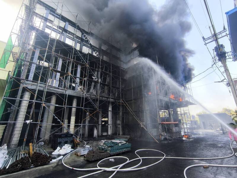 高雄市大社三楼建物发生火警，消防人员布水线灌救。（民众提供）