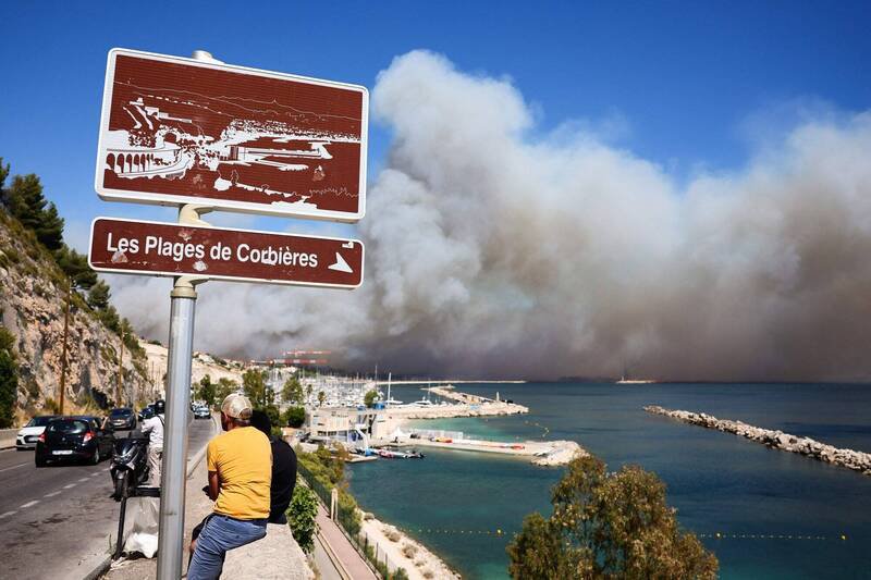 在法国南部马赛的科比耶尔海滩(Plage des Corbières)附近,人们注视著远处席卷而来的野火浓烟。(法新社)
在法国南部马赛的科比耶尔海滩(Plage des Corbières)附近,人们注视著远处席卷而来的野火浓烟。(法新社)