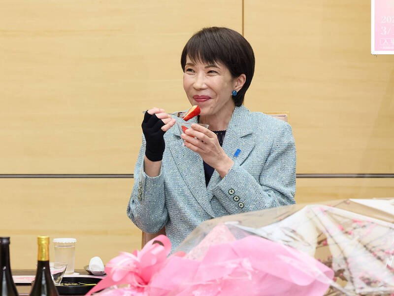 日本首相高市早苗17日在官邸接见茨城县古河市观光大使，食用水果时露出开心笑容。（撷取自日本首相官邸官网）