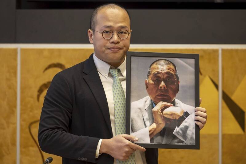 香港壹传媒集团创办人黎智英从2020年起被关押至今，还被判刑20年。美国总统川普证实，上周川习会中谈到黎智英。图为黎智英之子黎崇恩持黎智英的照片到联合国陈情。（美联社资料照）