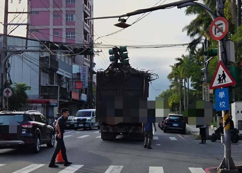宜兰市一辆抓斗车行经大坡路一处路口时，车上吊臂勾断交通号志。（图由警方提供）